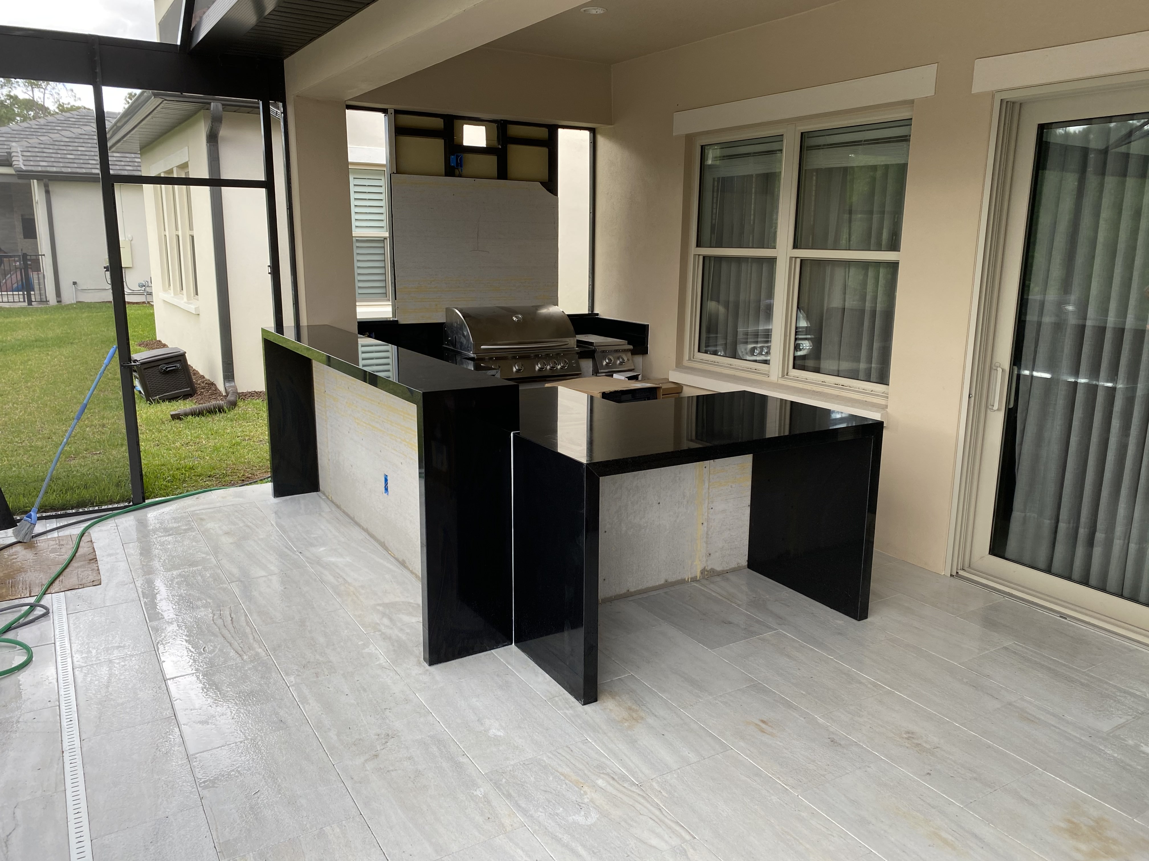 U-shaped outdoor kitchen with black granite